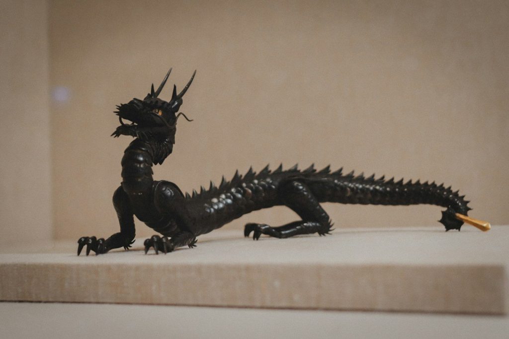A finished, intricate paper dragon model displayed on a desk